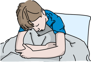 un enfant est malade, recroquevillé dans son lit